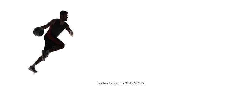 Dynamic silhouette of young man in motion with ball, training, playing isolated on white background. Concept of professional sport, competition, game, tournament. Banner. Empty space to insert text - Powered by Shutterstock