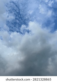 Dynamic sky featuring heavy, dark grey storm clouds contrasting with bright patches of blue sky and white clouds.