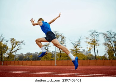 Dynamic steps leading to an impactful long jump. Bottom view full length portrait of professional sportsman running on sport field. Concept of kinds of sport, championship, motivation, energy. - Powered by Shutterstock