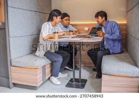 Dynamic team collaborating on project in modern booth
