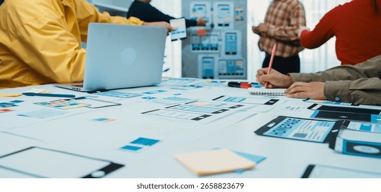 A dynamic team engaged in user interface design, surrounded by sketches, sticky notes, and a laptop, representing innovation and collaboration in a modern workspace. SACTR