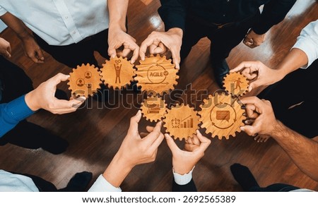 A dynamic teamwork scene featuring hands assembling wooden gears, symbolizing agile methodologies and collaborative strategies for business success and innovation. Amity