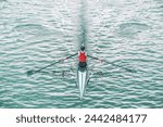 Dynamic top view photo of  a female competition rower pulling the paddle powerful.