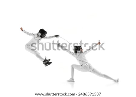 In dynamic training session, two female fencers clash swords, each testing other's defenses against white studio background. Concept of professional sport, competition, strength and power, action. Ad
