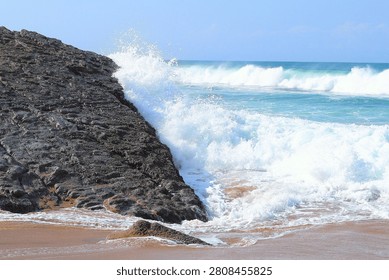 Dynamic view of powerful ocean waves crashing onto a rugged, rocky coastline, surrounded by swirling seafoam, capturing the untamed energy and natural beauty of a scenic seaside environment