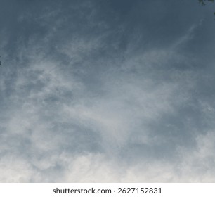 A dynamic view of the sky showcasing a blend of dark, moody clouds contrasted with areas of bright light. The scene evokes a sense of power and impending weather.