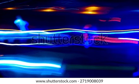 A dynamic visual of blue and pink light trails in a long exposure technique on a dark night road, creating an artistic and highly cinematic futuristic speed effect