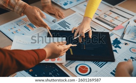 A dynamic workspace showcasing diverse hands engaging with data reports and digital displays, illustrating teamwork and collaborative analysis among professionals. SACTR