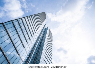 Dynamic worm's eye perspective of an elegant glass skyscraper stretching into the sky in Brussels with expansive copy space, expressing innovation, ambition and contemporary European business architecture