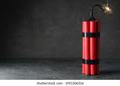 Dynamite Bomb With Lit Fuse On Grey Table, Space For Text