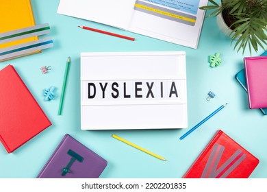 Dyslexia Awareness, Help Children With Reading, Learning Difficulties Concept. Lightbox With DYSLEXIA Word, Colorful Books And Open Book With Reading Highlight Bookmark Overlays Strips. Top View