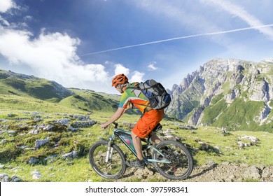 E bike traveler with backpack rides a mountain trail