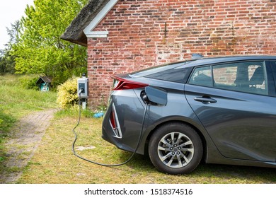 E Car At Charging Station In Front Of A Rural House