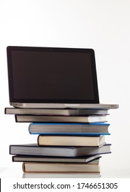 E Learning Concept. Books Stack And An Open Computer Laptop With Black Blank Screen Isolated On White Background. Vertical Photo, Copy Space, Template.