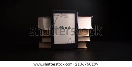 E reader. Digital e book, library reader tablet with books on dark background. Online education course, E learning class and ebook digital technology concept