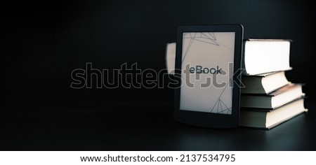 E reader. Digital e book, library reader tablet with books on dark background. Online education course, E learning class and ebook digital technology concept