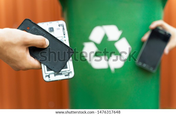 E waste , recycle concept , disassembled\
smartphone and recycle bin in background\
