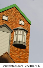 Each section includes a mix of light-colored, panel-covered windows and curved bay windows, all set against a partly cloudy sky.