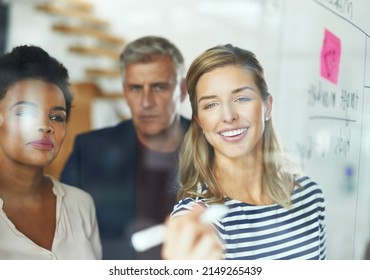 Eager To Get Behind A Winning Plan. Shot Of A Group Of Colleagues Having A Brainstorming Session In A Modern Office.