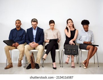 Eager To Make A Good Impression. Shot Of A Group Of Businesspeople Seated In Line While Waiting To Be Interviewed.