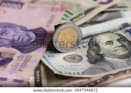 Eagle 5 pesos coin on Mexican peso dollar bills