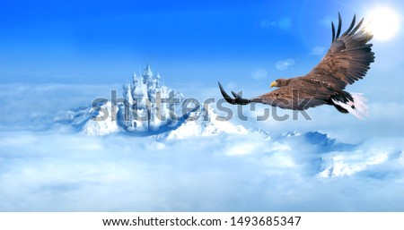 Eagle flying towards ice castle in snow mountains aerial view