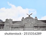 An eagle sculpture adorns the rooftop of a traditional street house facade on Xinhua Old Street, Tainan, reflecting the rich history and craftsmanship of early Taiwanese architecture.