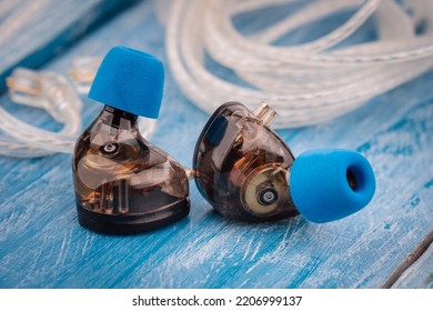 In ear monitor on a tablature background. Custom in-ear monitors with black plates. Custom in ear monitors or IEMs ready for a musician to wear on stage at a concert.