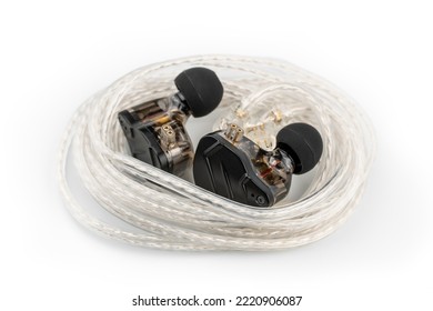 In ear monitor on a tablature background. Custom in-ear monitors with black plates. Custom in ear monitors or IEMs ready for a musician to wear on stage at a concert.