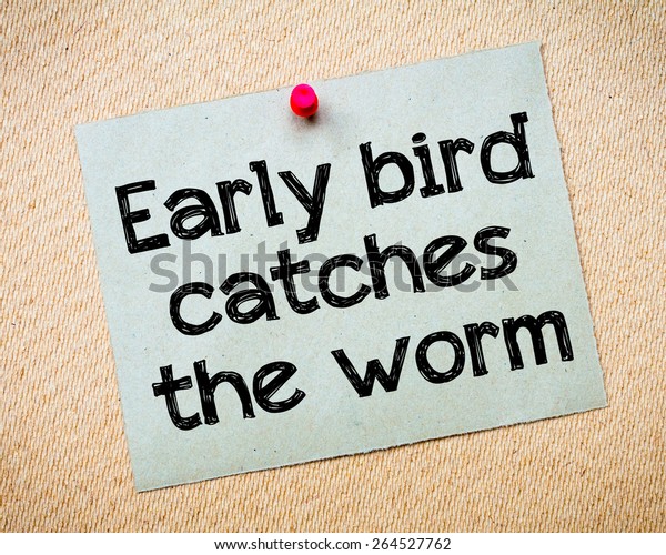 Early bird catches the worm Message.\
Recycled paper note pinned on cork board. Concept\
Image