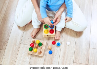 Early Child Development Concept. Close Up Of Hands Little Child And Mom Is Playing Wooden Toys Sitting On The Floor, Top View