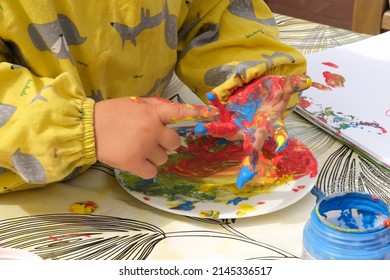 Early Childhood Development Activity: Finger Painting Outside On A Sunny Day