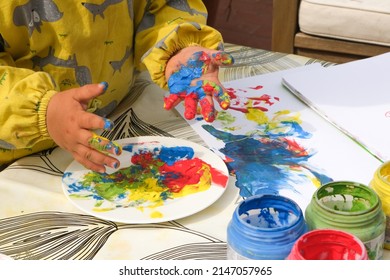 Early Childhood Development Activity: Finger Painting Outside On A Sunny Day