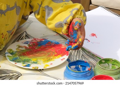 Early Childhood Development Activity: Finger Painting Outside On A Sunny Day