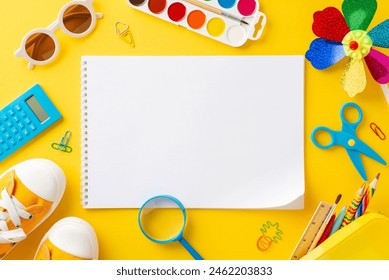 Early childhood summer enrichment theme. Top view of art essentials: sketchbook, colored pencils, paints, calculator, outdoor gear - sunhat, sunglasses, sneakers, pinwheel, and more on yellow backdrop - Powered by Shutterstock