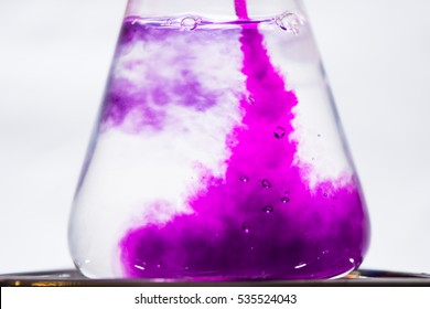 Frühe Farbveränderung bei chemischer Chamäleon-Reaktion. Intensive Rosa Kaliumpermanganatlösung wird violett, wenn sie in Saccharose und Natriumhydroxid in Wasser eingegossen wird