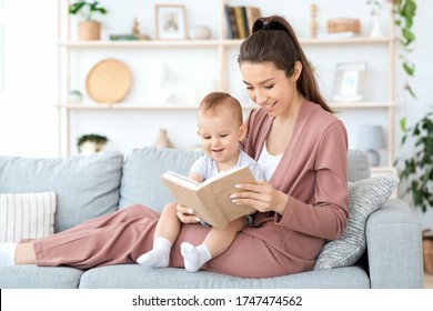 Early Development For Babies. Millennial Mom Reading Book To Her Adorable Toddler Baby Boy At Home, Sitting On Couch In Cozy Living Room, Free Space