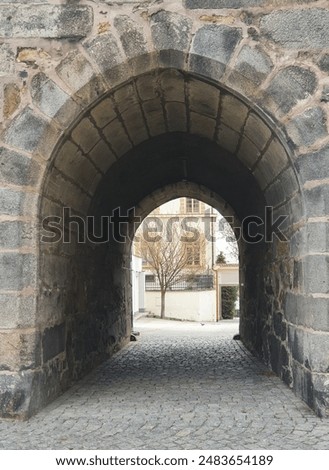 Early gothic arch gate through medieval ramparts. The thick stone wall was part of the fortifications of the city of Klatovy in the Czech Republic.