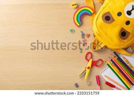 Early learning motif. Top view of colorful equipment, album, paint supplies, rainbow plasticine, paper clips, shears, cute bear backpack on wooden table with blank space for text or advertising