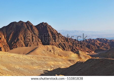 Early morning in ancient mountains of Sinai desert. Sunrise over Red sea