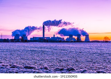 Early morning and a hard frost over agricultural fields in Drax, North Yorkshire. UK.  Sun rising to the East and water vapour trails from a local Power Station.  Horizontal.  Space for copy.