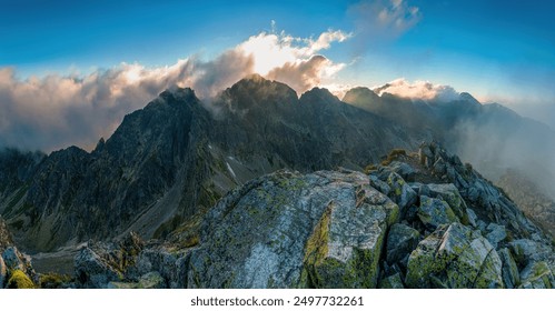 Early morning in High Tatras mountains, Slovakia. An amazing view of high rocky peaks surrounded by clouds during golden hour. Sunrise over High Tatras mountains from the top of Koprovsky peak. - Powered by Shutterstock