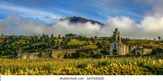 Early morning landscape shot of Hacienda Vista Hermosa in Puebla, Mexico as low clouds cover the background mountains. 