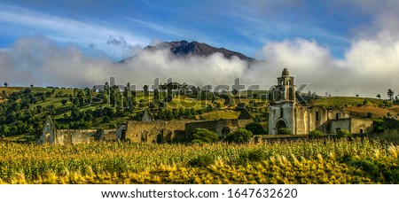 Early morning landscape shot of Hacienda Vista Hermosa in Puebla, Mexico as low clouds cover the background mountains. 