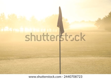Early Morning Light Casting a Warm Glow over a Misty Golf Course