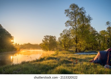 Early morning on the river with fog. Scenic colourful sunrise over river in Belarus. Beautiful morning landscape with camping tent and kayak on the river at sunrise - Powered by Shutterstock
