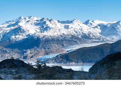 Early morning panoramic view over Lago Grey lake and terminus of Glacier Grey in Torres del Paine National Park, Chile with first light of sunrise on snow covered mountains along the glacier - Powered by Shutterstock