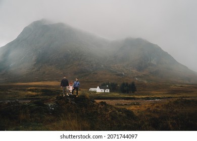 Early Morning Photo Of The Family, In Front Of The Foggy Scottish Highlands Landscape.