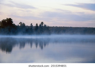 Early morning rising mist misty. Lake calm still water reflection reflections. Horizon shore trees woods sky clouds. Beautiful northern Ontario Canadian Shield. Pristine peaceful idyllic. Cottage. - Powered by Shutterstock