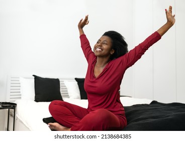 Early Morning Routine Of Beautiful African Woman Stretching Arms Outwards While Sitting On Bed, With Copy Space